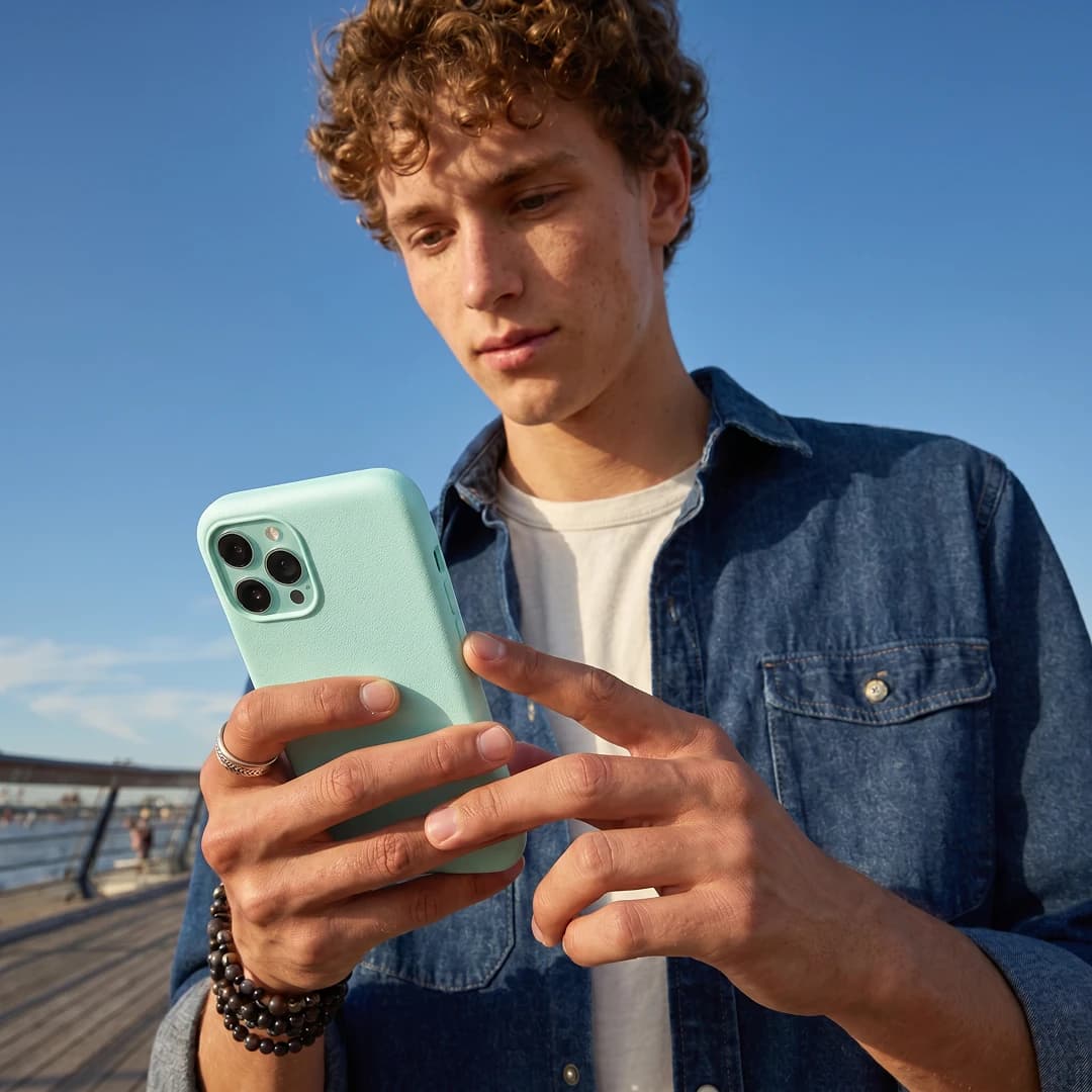 Student using a phone outdoors on a boardwalk