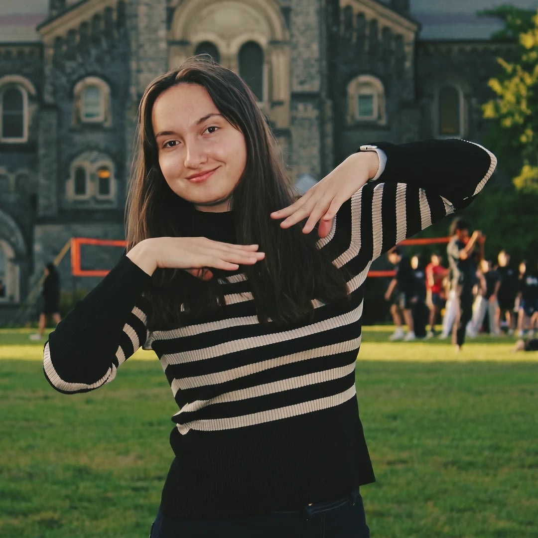 Anna making a level gesture outdoors