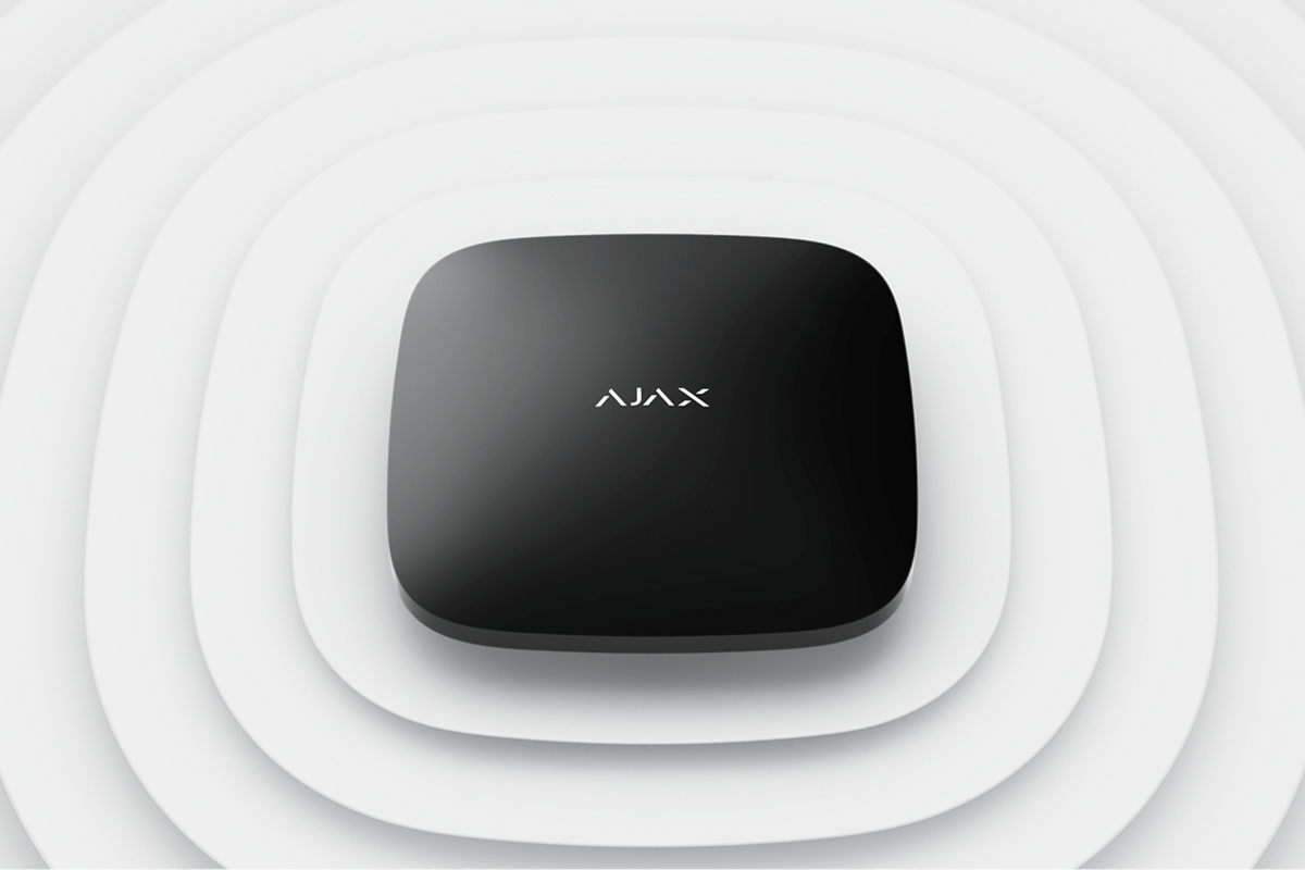 Sleek black AJAX security hub device with rounded corners on a textured white background.