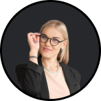 Smiling young woman with blonde hair in glasses and a black blazer.
