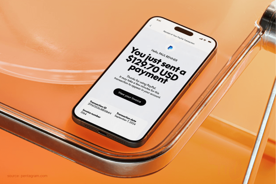 A smartphone on an orange surface displaying a payment confirmation screen.