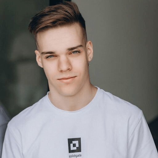 Young man with short brown hair and blue eyes wearing a white t-shirt.